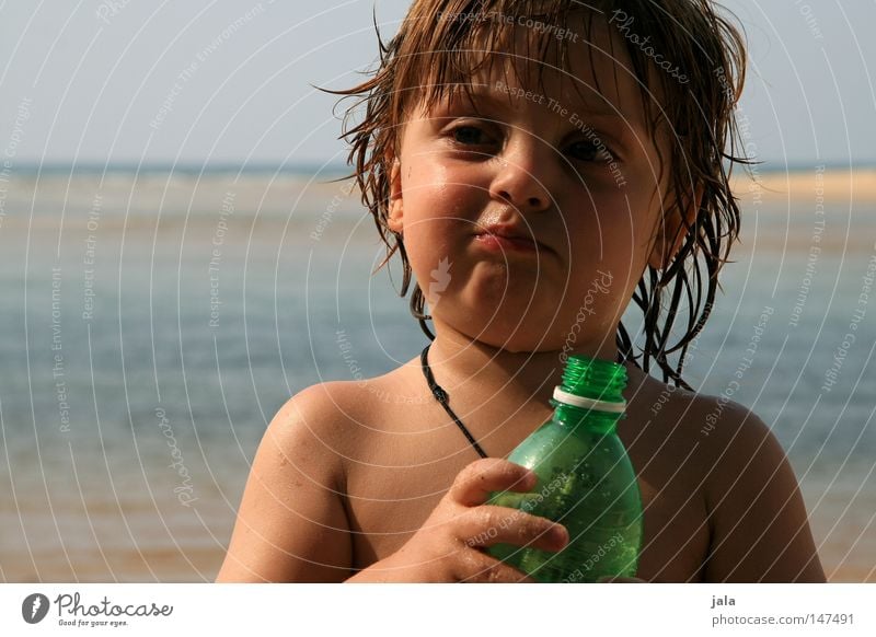 sommerkind Kind Ferien & Urlaub & Reisen Junge Gesicht Hand Wasser Meer Strand Flasche nass Gesichtsausdruck Lederband Schulter Sand Himmel Sommer Haut