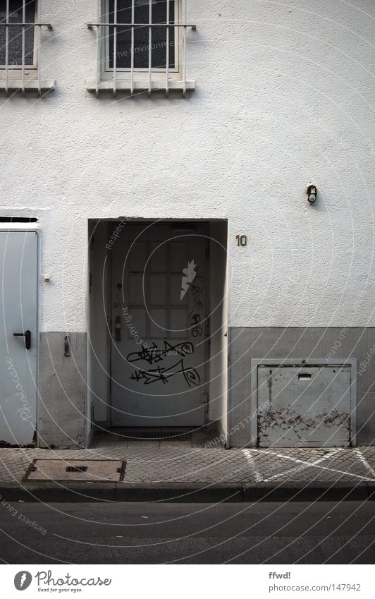 Kehrseite Wand Hinterhof Seitenstraße Rückseite Gebäude Fenster Gitter Tür Eingang Mauer Putz alt schäbig dreckig schädlich Graffiti Asphalt Gegenteil