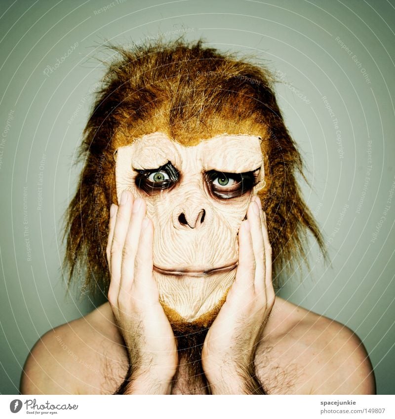 Ungeschminkt Trauer Entsetzen Affen Tier Maske Freude Traurigkeit verkleiden Schrecken Hand Innenaufnahme Mann Blick in die Kamera Irritation