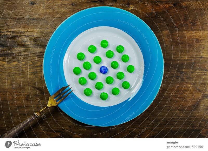 Auf den Punkt gebracht! Ein Teller mit einen blauen Rand, darauf viele grüne und eine blaue Kugel, Punkte und eine Gabel auf einem Holztisch Dessert Süßwaren