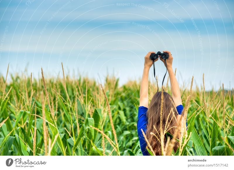 Frau, die ein Fernglas auf dem Gebiet hält Lifestyle Ferien & Urlaub & Reisen Erwachsene Natur Landschaft Himmel Horizont Gras frei wild Fernweh Idee Fundstück