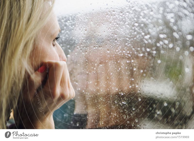 Blonde Frau blickt aus Fenster mit Regentropfen an Scheibe Wimperntusche Wohnung Junge Frau Gesicht Hand Mensch 30-45 Jahre Erwachsene schlechtes Wetter Glas