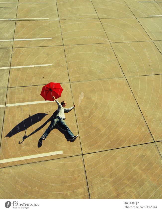 EIN FOTO VON DER STANGE Regenschirm Mensch rot Beton Vogelperspektive Parkplatz Parkdeck Schönes Wetter Schatten Mann maskulin stehen liegen Sonnenschirm Schirm