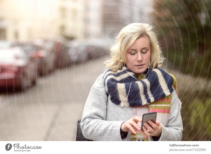Attraktive blonde Frau, die ihren Handy überprüft Winter Business sprechen Telefon Technik & Technologie Erwachsene 1 Mensch 30-45 Jahre Straße Mode Lächeln