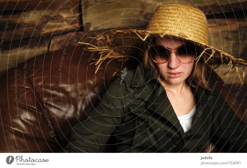 prost neujahr! Frau Mensch Porträt Strohhut Holzwand Sessel Leder Sonnenbrille Coolness sitzen Misstrauen abgebrüht Gesicht Macht