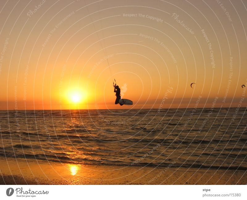 Nightsurfing Kitesurfer Sonnenuntergang Meer Wellen Strand Sport fliegen Abend