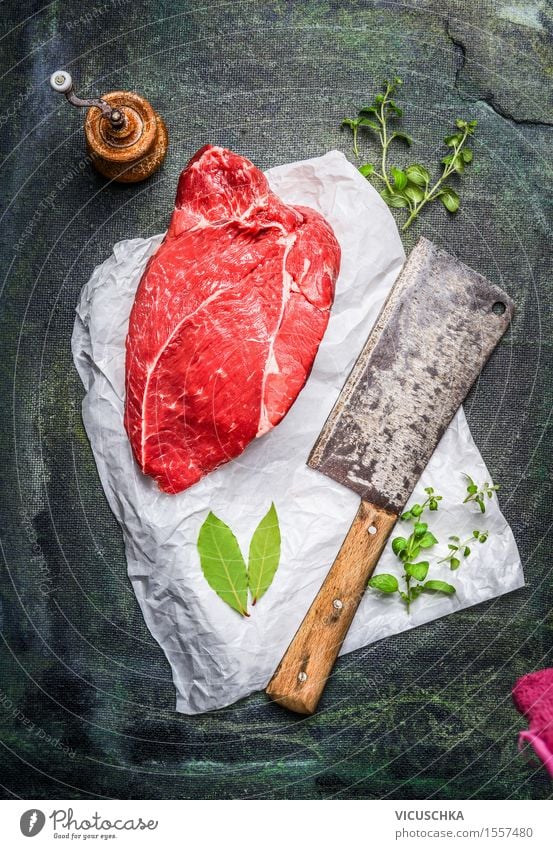 Stück rohes Fleisch auf weißem Papier mit Hackbeil Lebensmittel Kräuter & Gewürze Ernährung Mittagessen Bioprodukte Diät Messer Gesunde Ernährung Tisch Küche