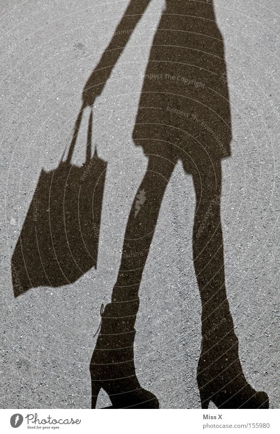 Shoppingtour kaufen Frau Erwachsene Beine Straße Schuhe grau schwarz Lebensfreude Asphalt steinig unterwegs Schattenspiel Kies Tüte Konsum Farbfoto