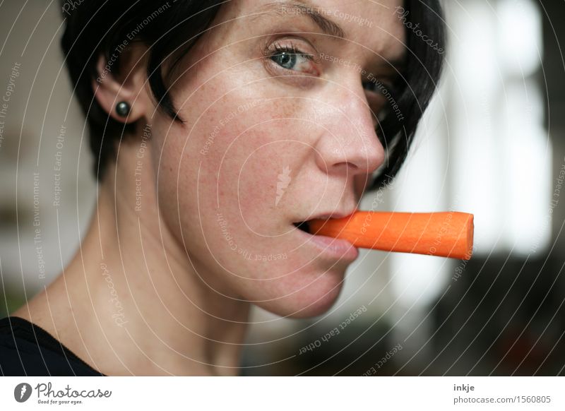 Frau mit Möhre statt Zigarette im Mundwinkel Lebensmittel Gemüse Rohkost Ernährung Essen Bioprodukte Vegetarische Ernährung Diät Lifestyle Stil Erwachsene