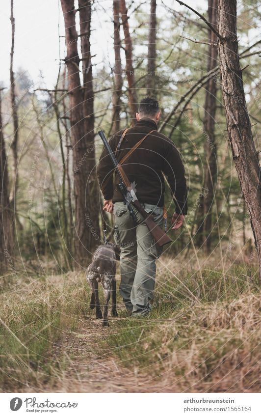 Junger Jäger mit Gewehr und sein Jagdhund wandern im Wald Freizeit & Hobby Ausflug Mensch maskulin Junger Mann Jugendliche Freundschaft Leben 1 30-45 Jahre