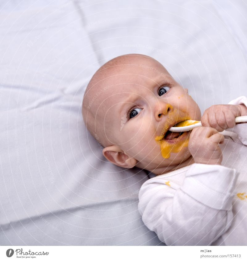 Trefferquote. Baby Brei Ernährung Löffel weiß Porträt Mund Hand klecksen Essen Schmiererei Kinderportrait Kindergesicht Vor hellem Hintergrund Freisteller