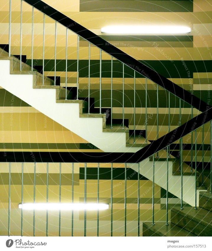 Treppenhaus Niveau Geländer Treppengeländer Neonlicht Leuchtstoffröhre Zickzack braun Linie aufwärts abwärts Eingang Detailaufnahme Flur Wandgestaltung