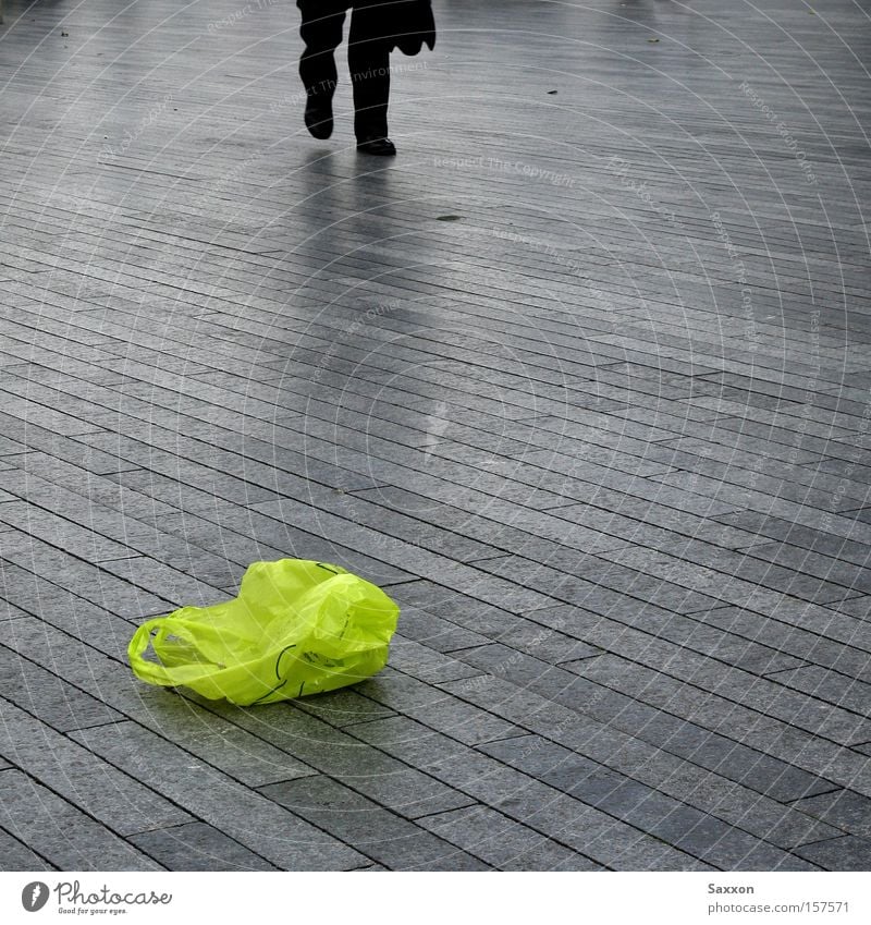Die grüne Tüte Promenade Bürgersteig Fußweg Müll Recycling Arbeitsweg Farbfleck trist Einsamkeit Verkehrswege Pflastersteine Eile