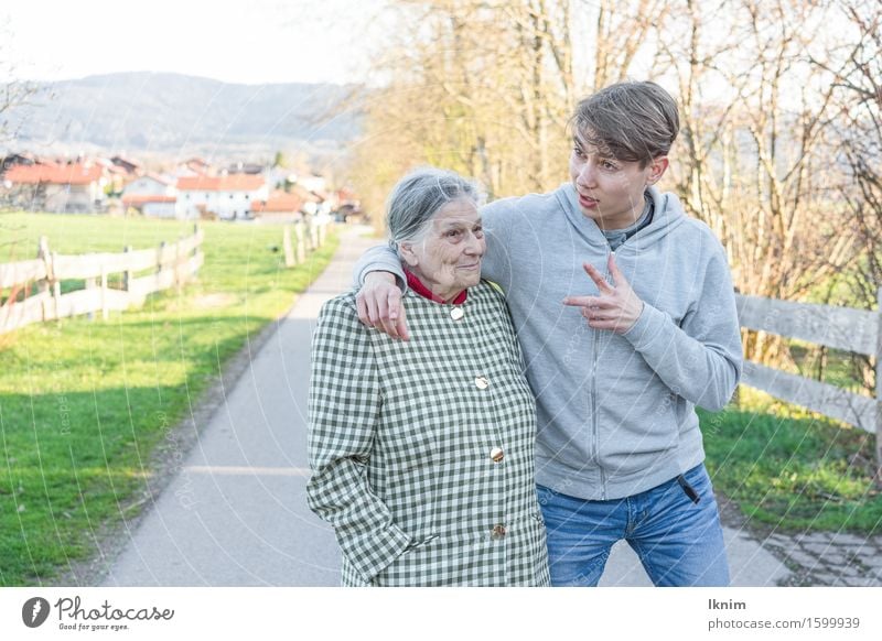 junger Mann und alte Frau unterhalten sich bei einem Spaziergang Gesundheitswesen Seniorenpflege Junger Mann Jugendliche Weiblicher Senior Großmutter