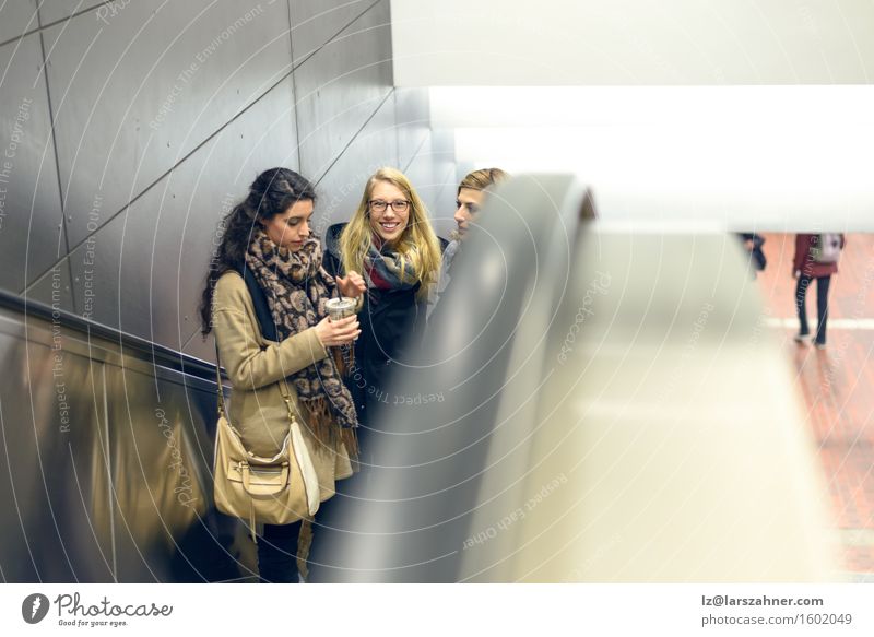 Drei junge Frauen, die Rolltreppe hochziehen Glück Erwachsene Freundschaft 3 Mensch 18-30 Jahre Jugendliche Eisenbahn Schal brünett blond Lächeln attraktiv