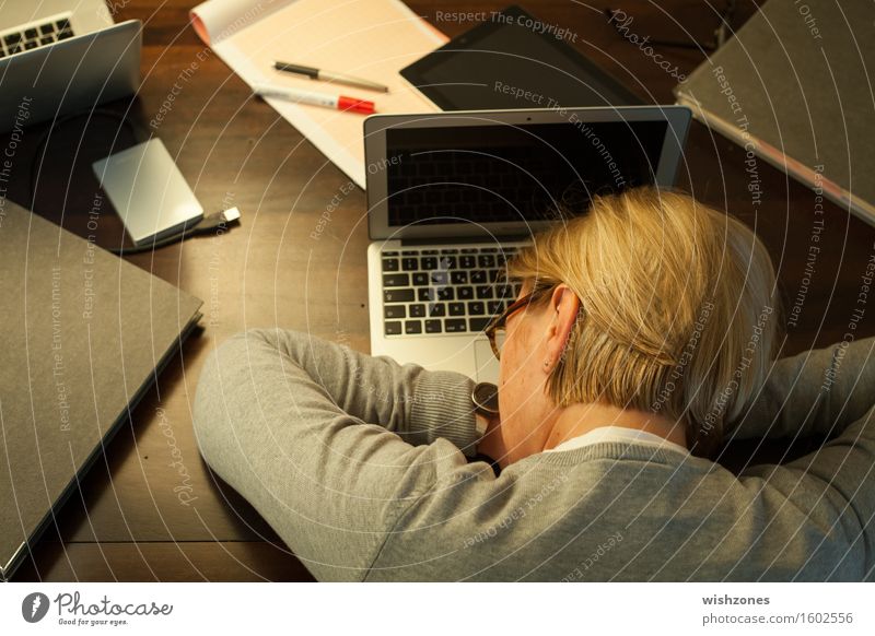 Woman sleeping on office desk Computer Notebook Tastatur Technik & Technologie Frau Erwachsene 1 Mensch 45-60 Jahre Schreibwaren Aktenordner Erholung schlafen