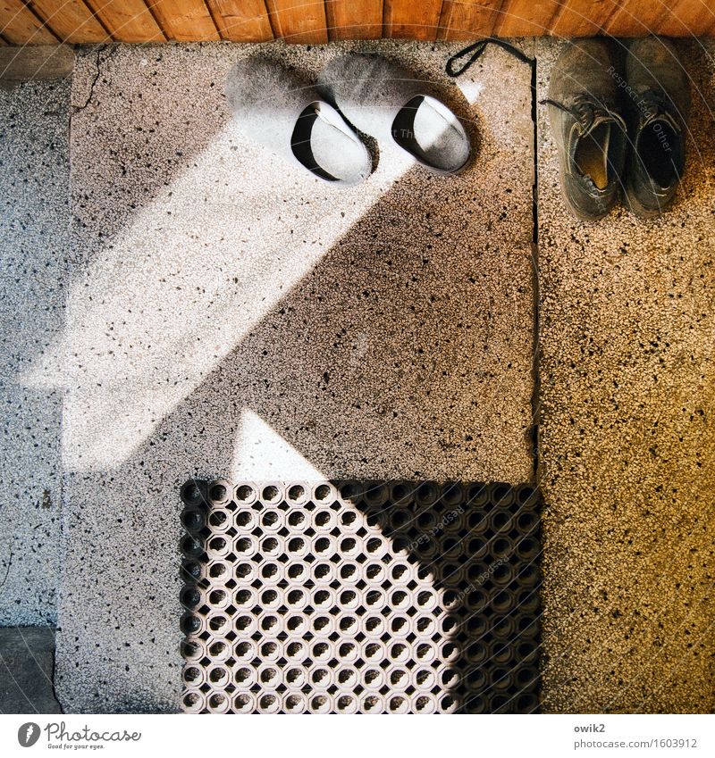 Zwei Paar Schuhe Hausschuhe paarweise Fußmatte Gummi Terrakotta Fußboden Stein Holz Kunststoff warten unten Gelassenheit geduldig ruhig Lichteinfall Feierabend