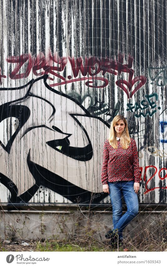 Lässig feminin Frau Erwachsene Freundschaft Leben Körper Beine 1 Mensch 30-45 Jahre Graffiti Stadtrand Mauer Wand Fassade Blech Jeanshose blond langhaarig Beton