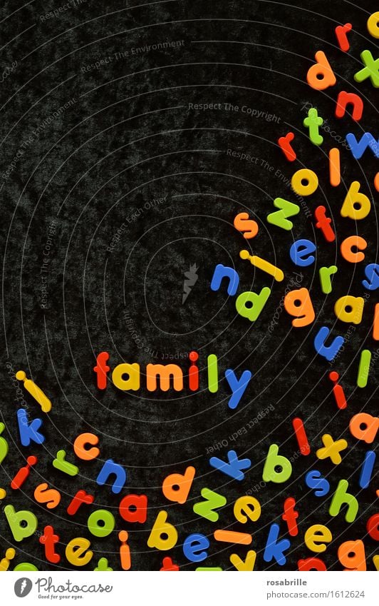 bunte Familie - bunte Magnetbuchstaben auf schwarzem Samt und dazwischen das Wort FAMILY gelegt Freude Spielen Kinderspiel Kindererziehung Bildung Kindergarten