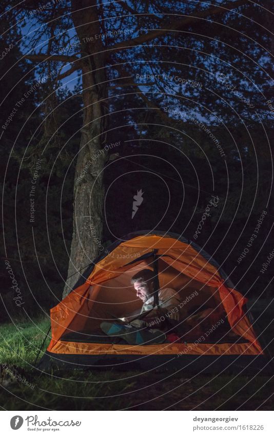 Mann, der seinen Smartphone in einem Zelt aufpasst Lifestyle Glück Ferien & Urlaub & Reisen Abenteuer Camping Sommer wandern Telefon PDA Mensch Erwachsene