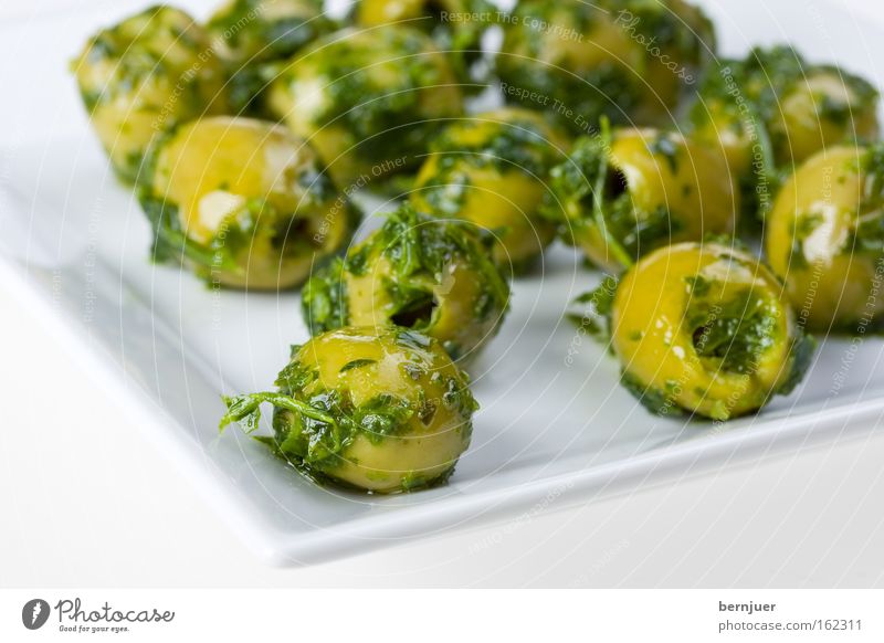 Oliven auf einem eckigen Teller Kräuter & Gewürze Snack Vorspeise Ernährung eingelegt kernlos entkernt