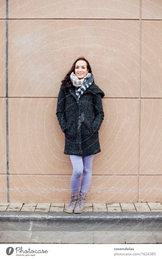 Smile Lifestyle Winter Student feminin Junge Frau Jugendliche 1 Mensch 18-30 Jahre Erwachsene Stadt Mauer Wand Fassade Jacke Mantel Schal brünett langhaarig