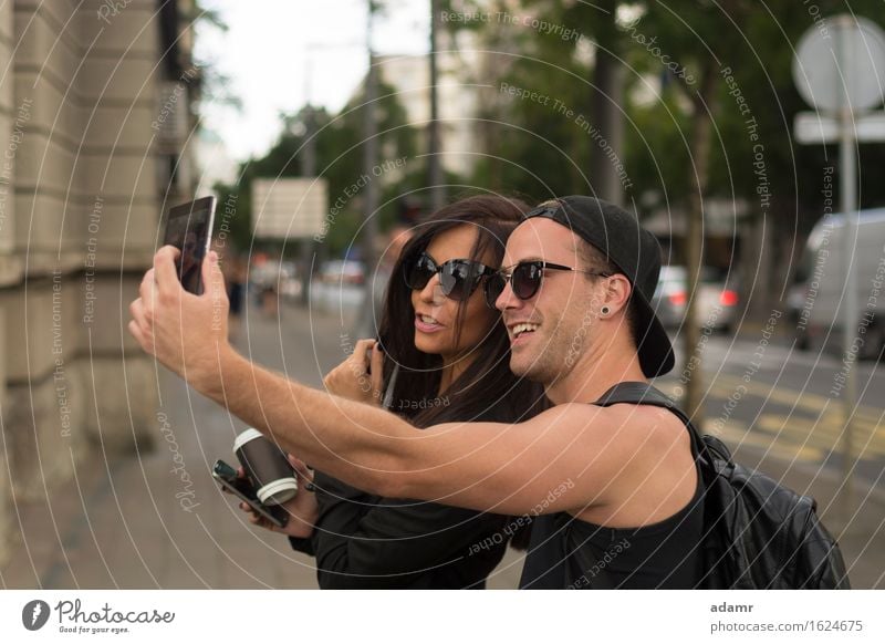 Fröhliche Freunde fotografieren sich selbst mit einem Smartphone Selfie Freundschaft Frauen Männer Menschengruppe Internet Straße Spaß Foto Fröhlichkeit heiter
