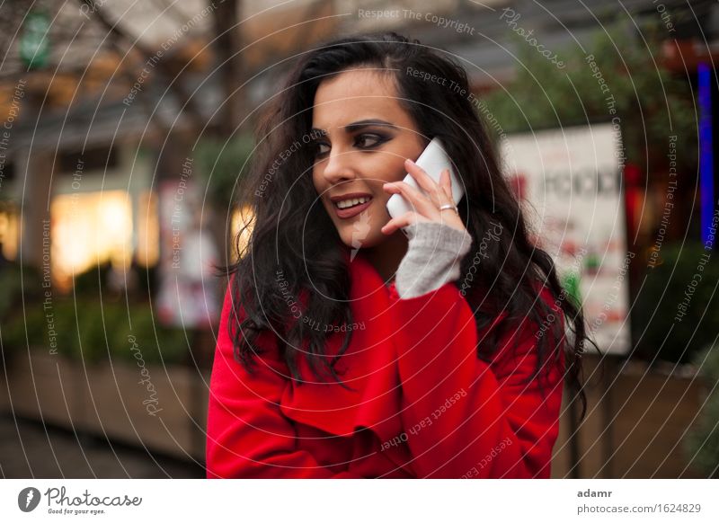 Frau in rotem Mantel mit Handy in der Hand, Smartphone, Stadtszene Telefon Lächeln Lifestyle Mädchen Mobile Person kalt Winter Technik & Technologie Zelle