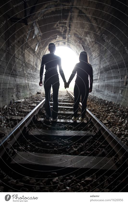 Paar, das gemeinsam durch einen Eisenbahntunnel geht Abenteuer gewölbt Asyl hell Konzept Gefahr dunkel Auswanderer flüchtig verborgen Händchenhalten Hoffnung