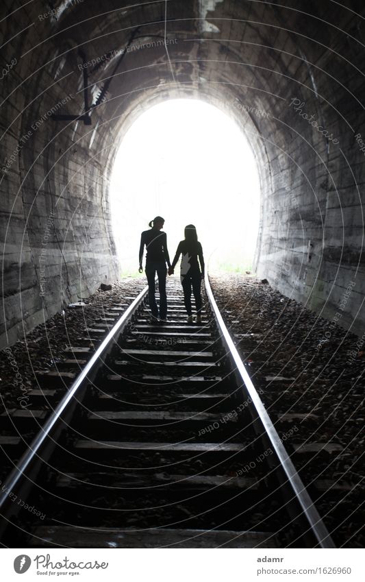 Paar, das gemeinsam durch einen Eisenbahntunnel geht Abenteuer gewölbt Asyl hell Konzept Gefahr dunkel Auswanderer flüchtig verborgen Händchenhalten Hoffnung
