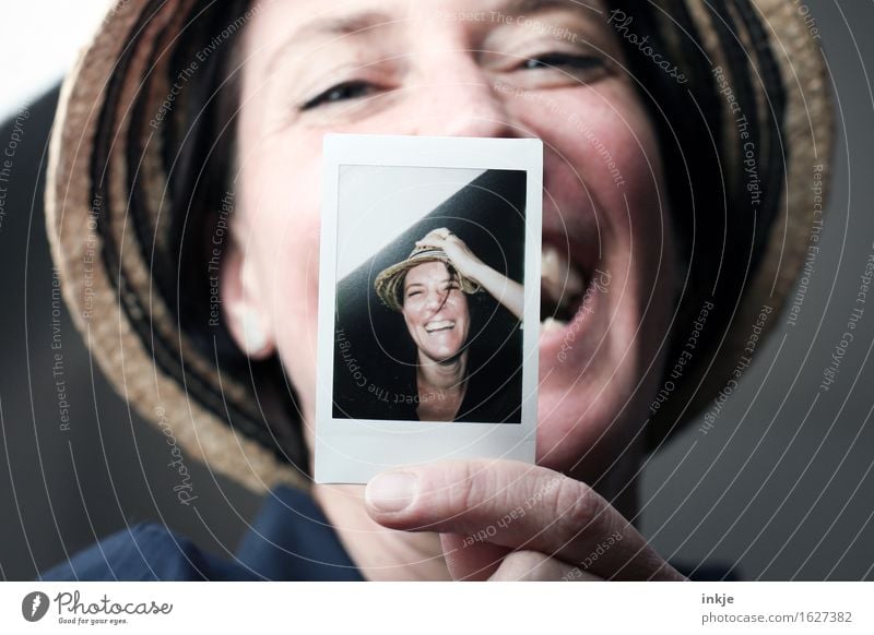 Lachende Frau zeigt Polaroid einer lächelnden Frau Lifestyle Stil Freude Freizeit & Hobby Erwachsene Leben Gesicht 1 Mensch 2 30-45 Jahre Hut Strohhut
