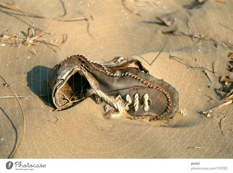 Alter Schuh Strand Schuhe alt Sand Strangut zerschließen weggeworfen