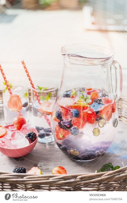 Krug mit Wasser , Beeren und Eiswürfel auf dem Gartentisch Lebensmittel Frucht Getränk Erfrischungsgetränk Limonade Saft Glas Stil Design Gesunde Ernährung