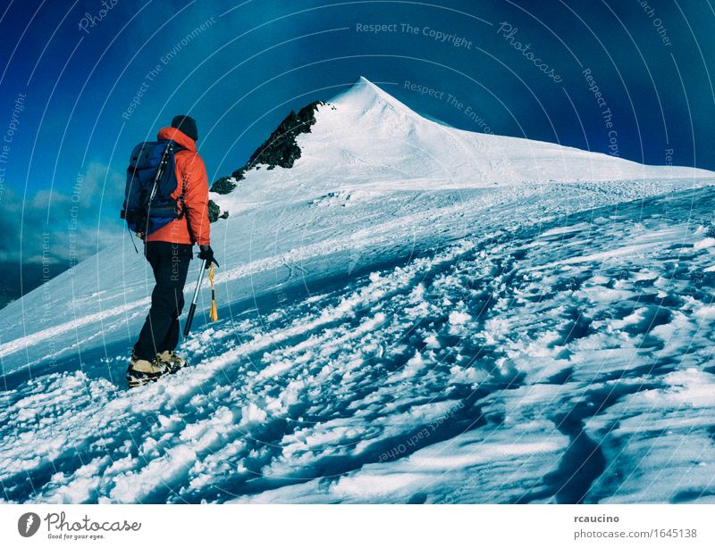 Mountaineer klettert einen schneebedeckten Gipfel. Klettern Bergsteigen Ferien & Urlaub & Reisen wandern selbstbewußt Erfolg Kraft Leidenschaft