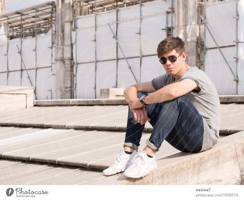 Er sitzt maskulin Junger Mann Jugendliche Bruder 1 Mensch 13-18 Jahre Mode T-Shirt Jeanshose Sonnenbrille Turnschuh beobachten hocken frei sportlich