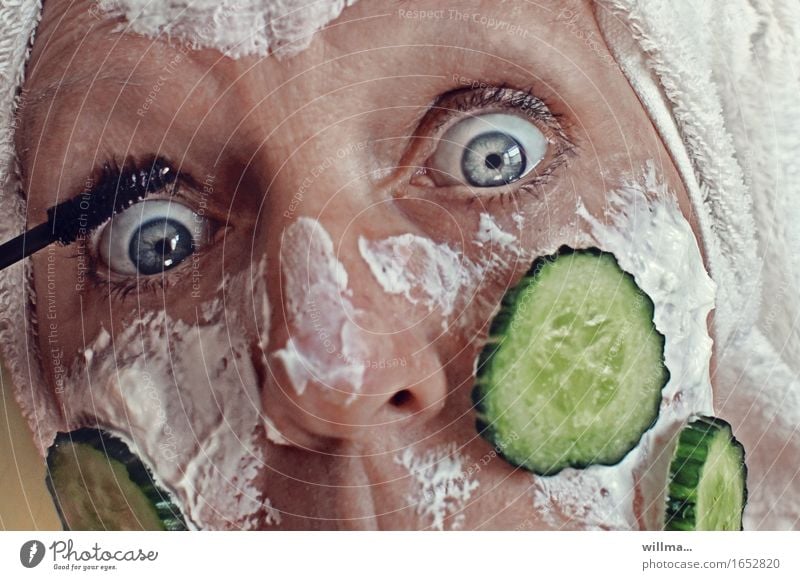 Frau mit Quarkmaske und Gurkenscheiben im Gesicht schminkt sich schön Haut Kosmetik Creme Schminke Wimperntusche feminin Erwachsene Weiblicher Senior Leben alt