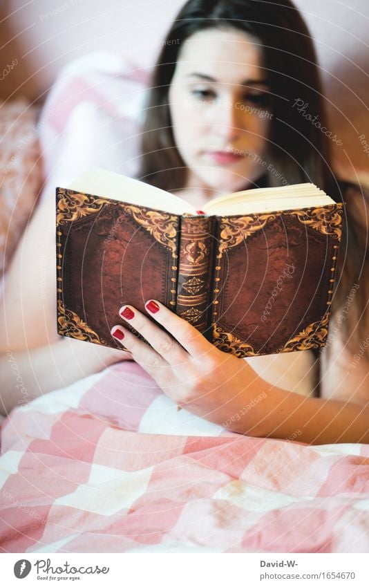 junge Frau liest Buch im Bett lesen Junge Frau Mädchen lernen Roman spannend Leseratte gefesselt Bettdecke gemütlich konzentriert hobby zu hause bleiben
