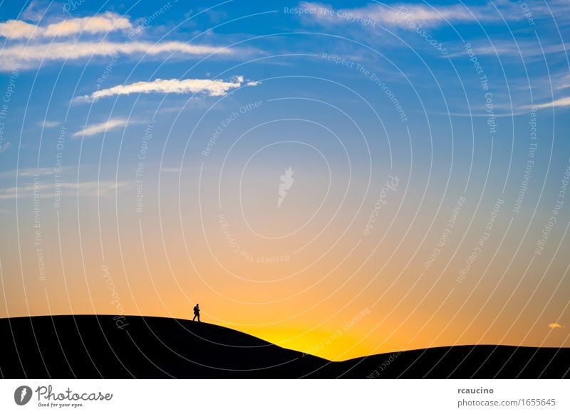 Bemannen Sie das Gehen auf eine Sanddüne in der Wüste bei Sonnenuntergang Stimmung Mut Schutz schön Wachsamkeit Pünktlichkeit Vorsicht geduldig Ehrlichkeit
