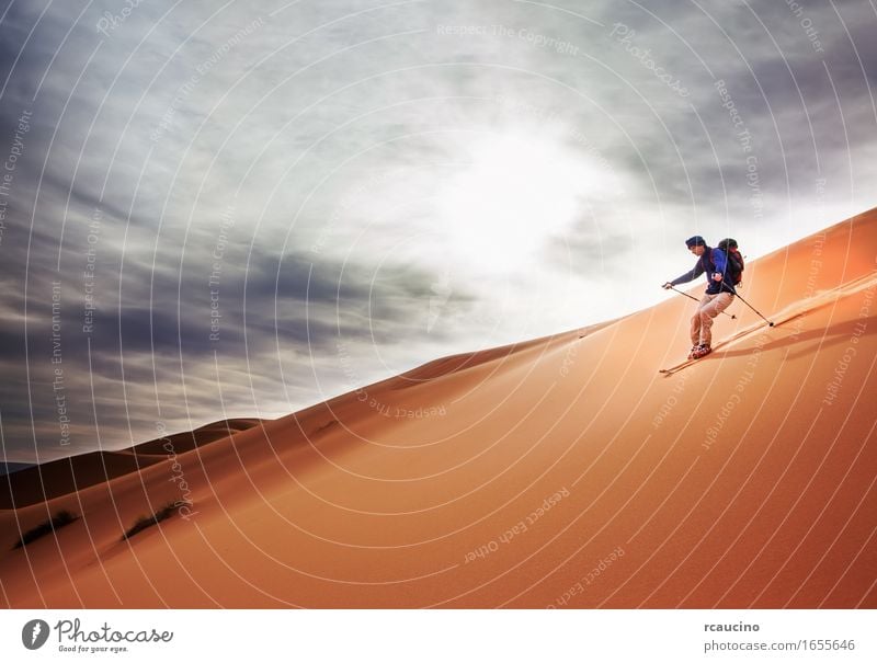 Ein Skifahrer geht auf einer großen Sanddüne in der Wüste Sahara bergab. Ferien & Urlaub & Reisen Ausflug Abenteuer Freiheit Expedition wandern Sport