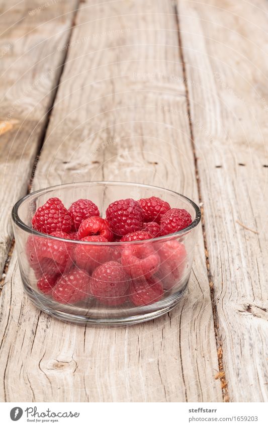 Klarglasschüssel reife Himbeeren Lebensmittel Frucht Ernährung Essen Bioprodukte Vegetarische Ernährung Diät Pflanze Holz Glas rosa rot Farbfoto Morgen