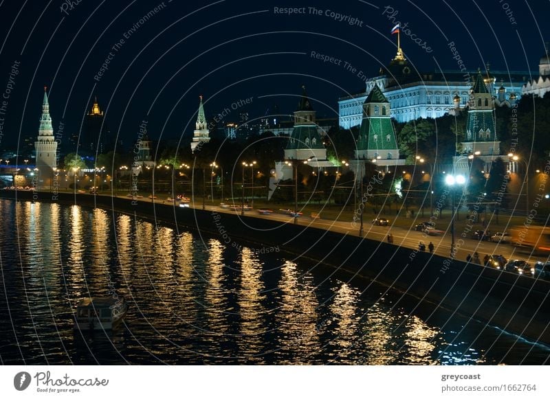 Eine Nachtansicht des Moskauer Kremls mit einem beleuchteten Fluss und einem Boot. Ferien & Urlaub & Reisen Landschaft Stadt Palast Brücke Gebäude Architektur