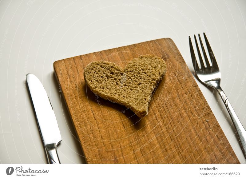Herz Lebensmittel Brot Ernährung Frühstück Besteck Messer Gabel Glück harmonisch Valentinstag Liebe Romantik Holzbrett Schneidebrett Farbfoto Innenaufnahme