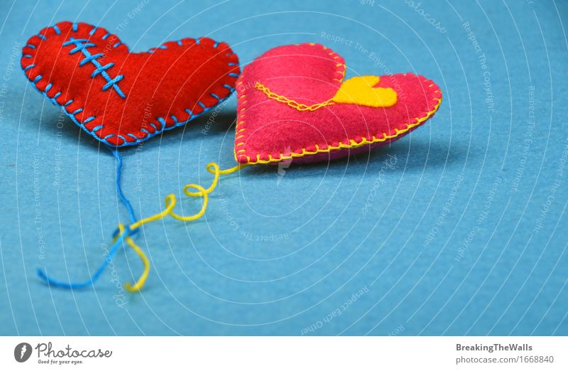 Zwei Spielzeugherzen mit Threads, rot und pink auf blauem Filz Freizeit & Hobby Handarbeit Valentinstag Hochzeit Kunst Kunstwerk Herz Liebe nah weich gelb rosa