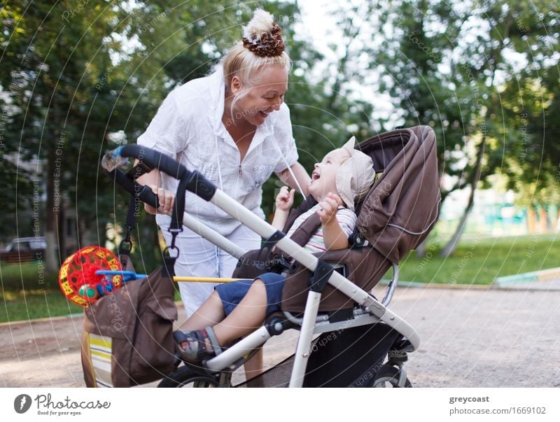 Oma spielt mit ihrem Enkel im Kinderwagen im Garten. Lifestyle Freude Glück schön Spielen Mensch Baby Junge Frau Erwachsene Weiblicher Senior Mutter Großvater