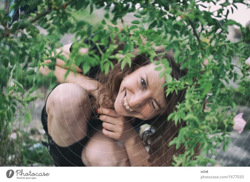 Portrait Mensch feminin Junge Frau Jugendliche Kopf Gesicht Knie 1 18-30 Jahre Erwachsene Natur Pflanze Sommer Garten Park brünett Locken knien Lächeln frech