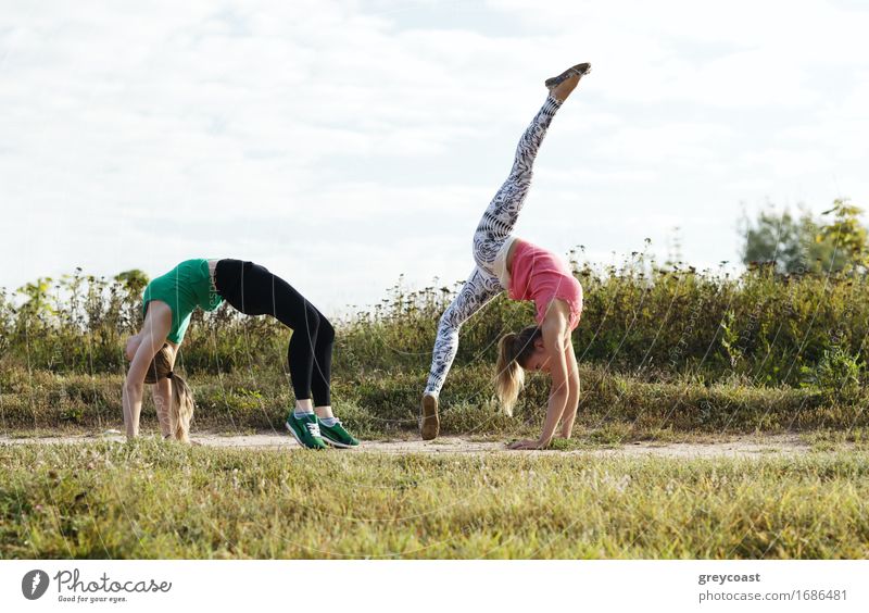 Zwei junge Mädchen trainieren gemeinsam im Freien: Dehnungsübungen Fitness Sport-Training Mensch Junge Frau Jugendliche Erwachsene Freundschaft 2 18-30 Jahre