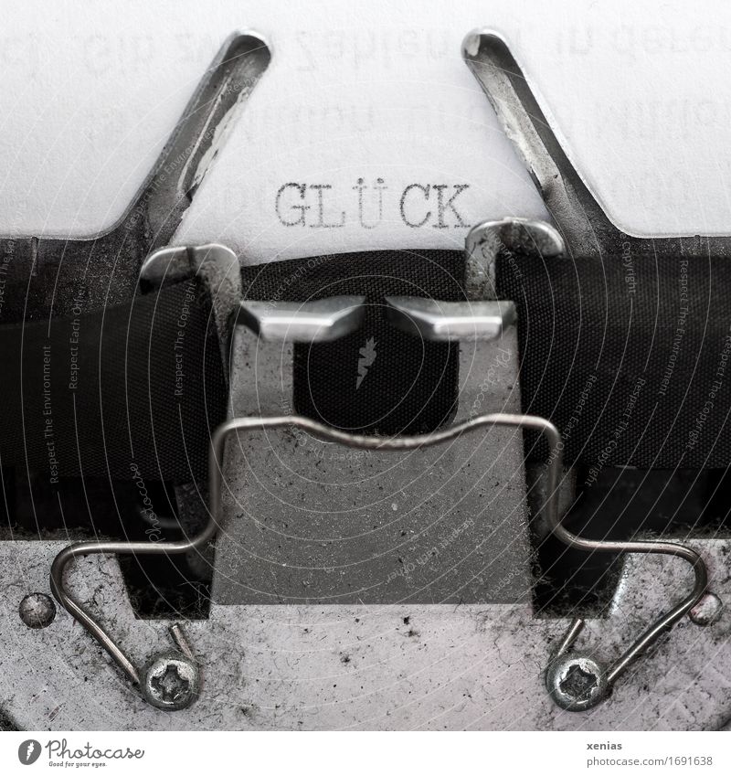 Das Wort Glück mit einer Schreibmaschine geschrieben Hoffnung Schriftzeichen schreiben Buchstaben schwarz silber weiß Freude Papier Metall retro Maschine Brief