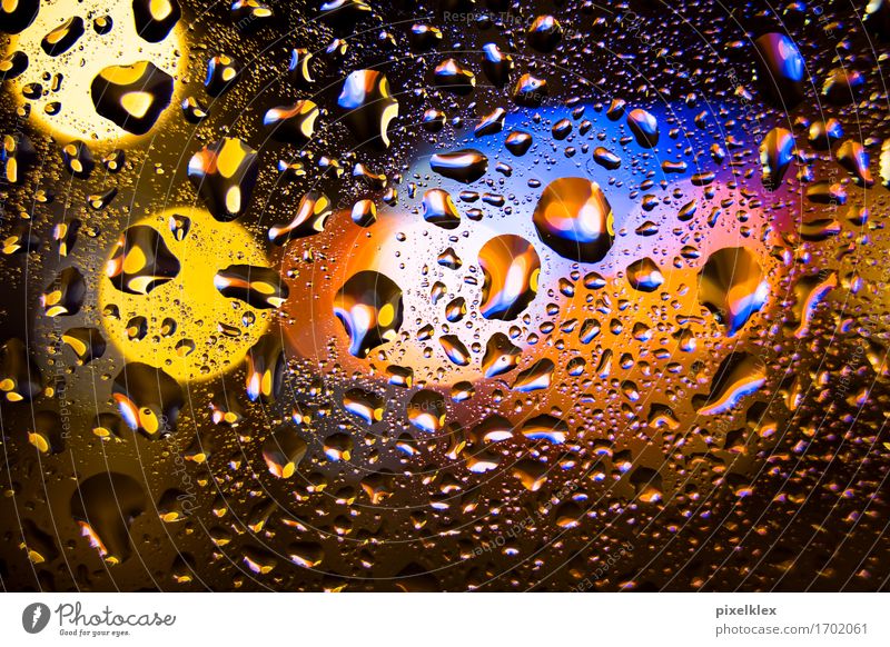 Regentropfen am Fenster Nachtleben Wasser Wassertropfen schlechtes Wetter Menschenleer Glas leuchten glänzend nass blau gelb orange Licht Scheibe Fensterscheibe
