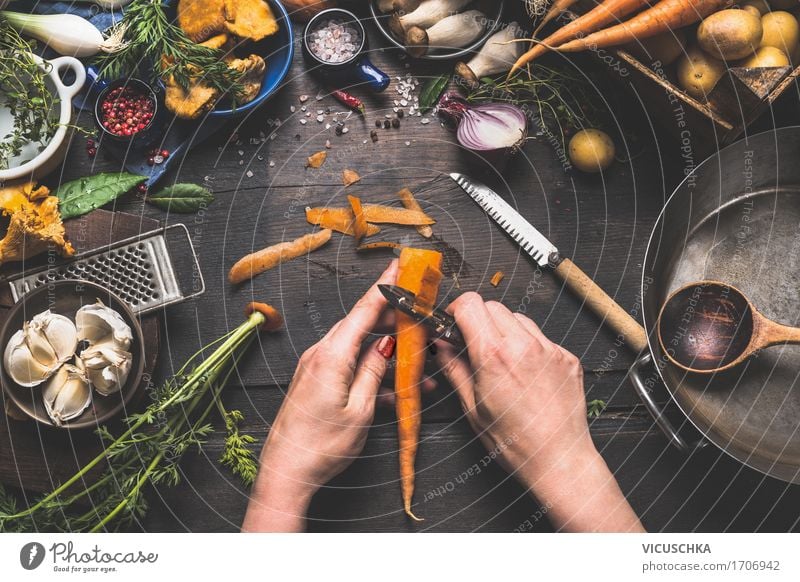 Frauenhände schälen Möhre auf dunklem Küchentisch Lebensmittel Gemüse Kräuter & Gewürze Ernährung Mittagessen Bioprodukte Vegetarische Ernährung Diät Geschirr