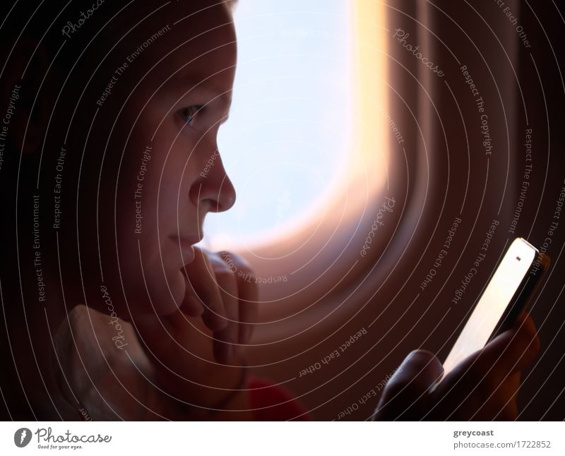 Junge Frau sucht während des Fluges nach Fotos in ihrem Smartphone lesen Ferien & Urlaub & Reisen Telefon Bildschirm Technik & Technologie Internet Mensch Hand